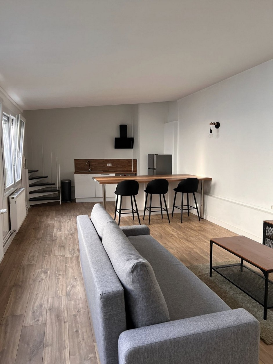 Intérieur rénové d'un T3 à Lens avec escalier hélicoïdal et séjour meublé