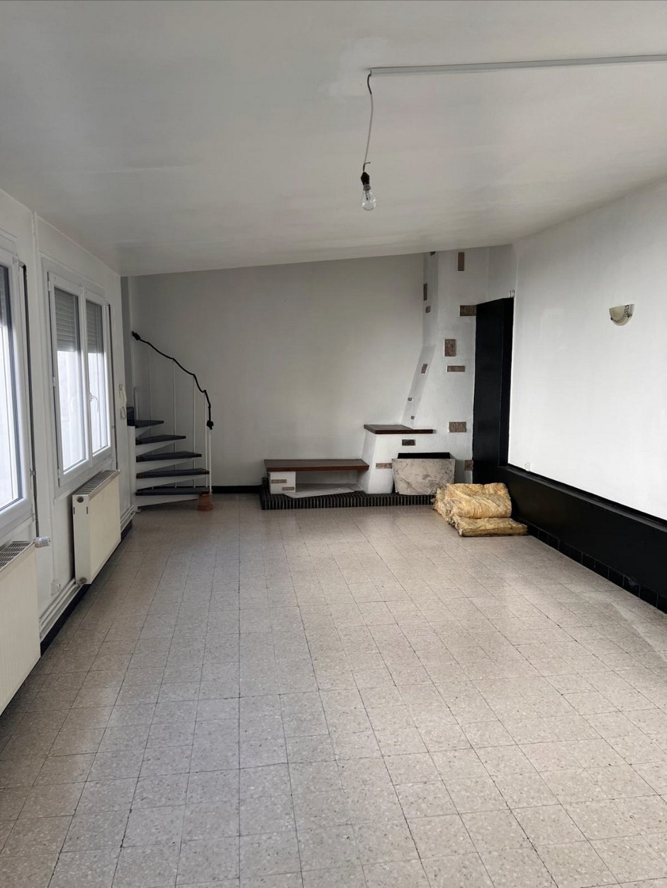 Intérieur rénové d'un T3 à Lens avec escalier hélicoïdal et séjour meublé
